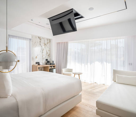 Ethereal White Resort Heraklion Luxury Suite double bed, couch and room amenities