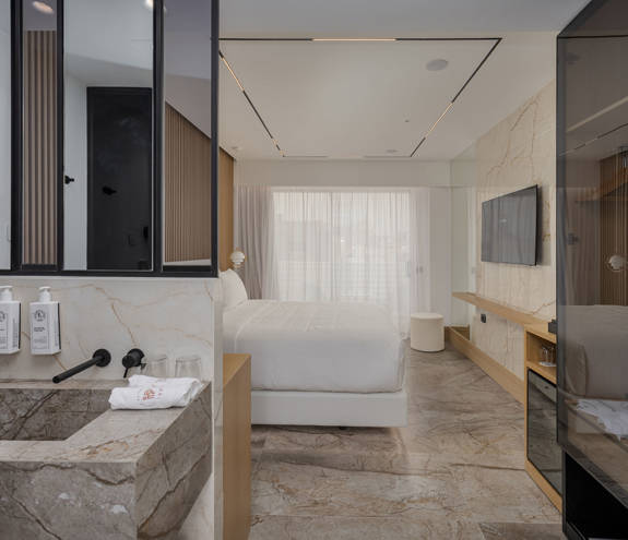 Ethereal White Resort Heraklion Deluxe Suite Swim Up washbasin and the double bed in the background