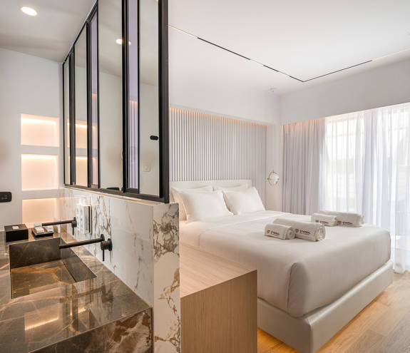 Ethereal White Resort Heraklion Junior Suite washbasins and the double bed in the background