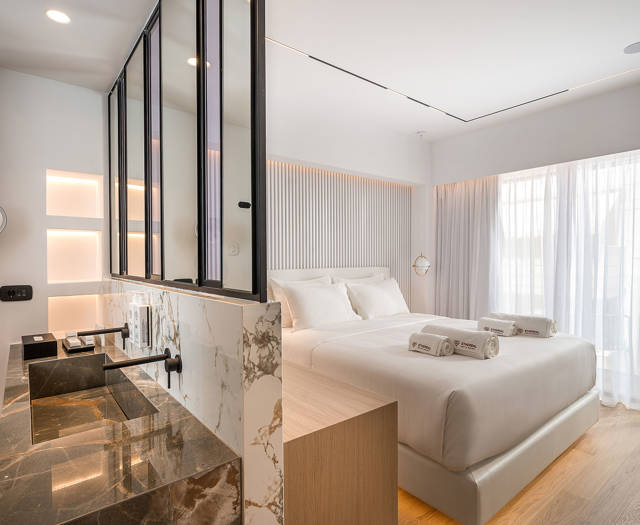 Ethereal White Resort Heraklion Junior Suite washbasins and the double bed in the background
