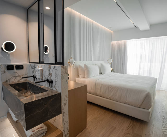Ethereal White Resort Heraklion Deluxe Suite washbasins and the double bed in the background